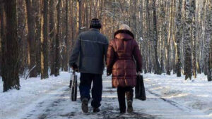 An elderly couple walking on winter road