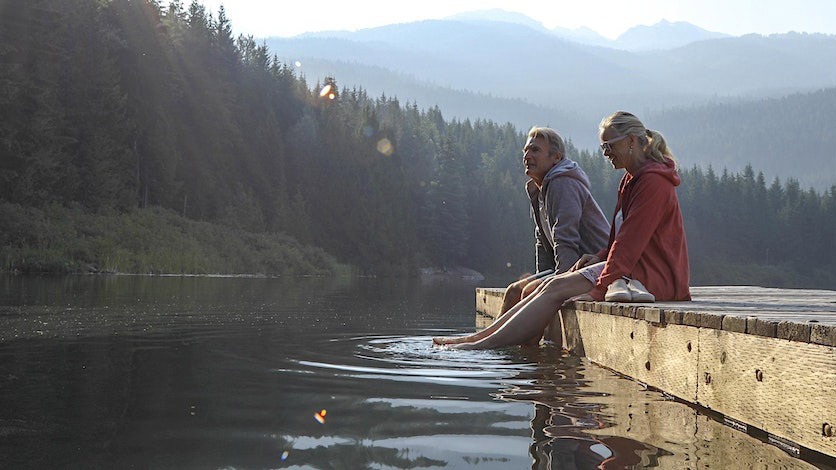 Two older adults relaxing at a lake