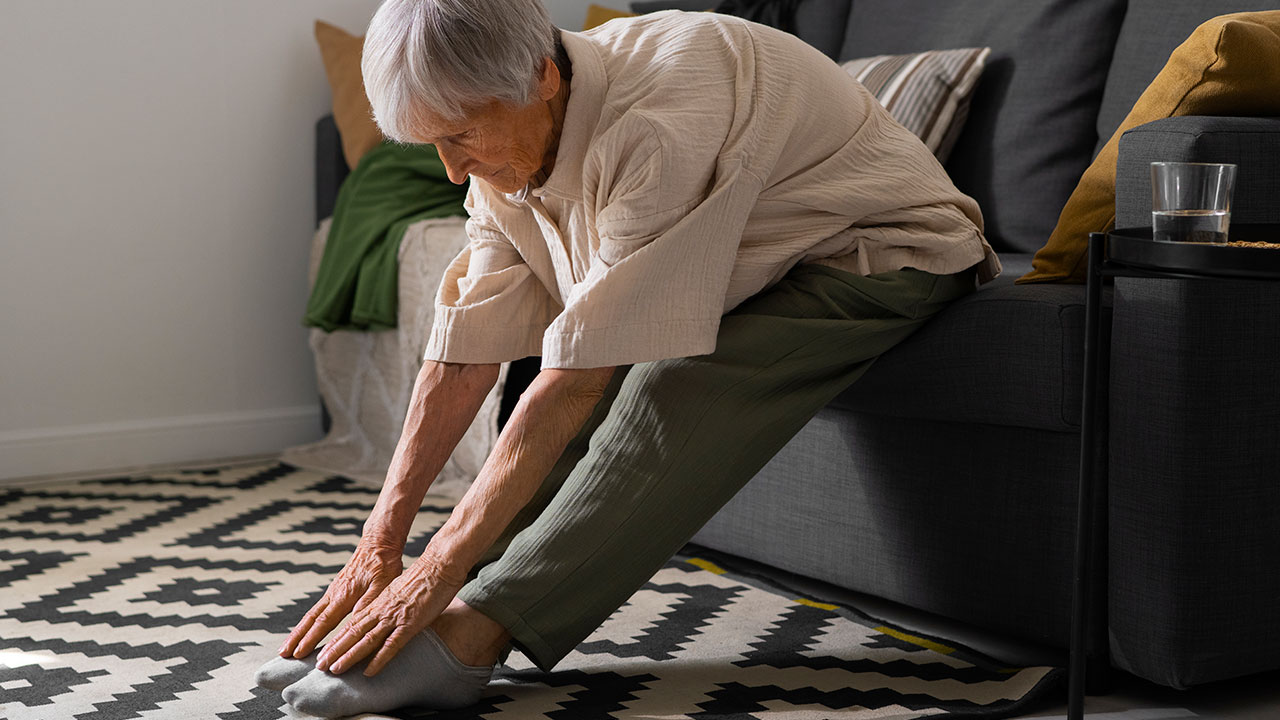 An older person stretching on couch