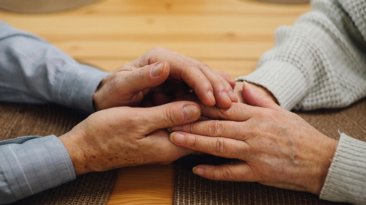 Two pairs hands holding